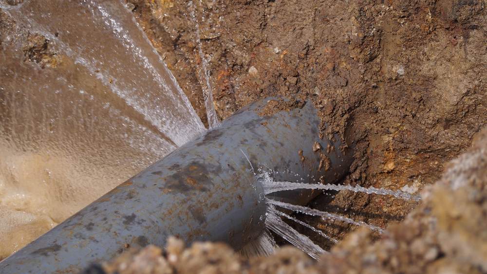 A leaking water pipe illustrating the water cost of non-revenue water
